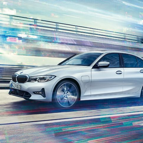 BMW 3 Series Sedan, side view of the driving BMW 3 Series Sedan 330e. Side view of the driving BMW 3 Series Sedan 330e in front of urban backround.