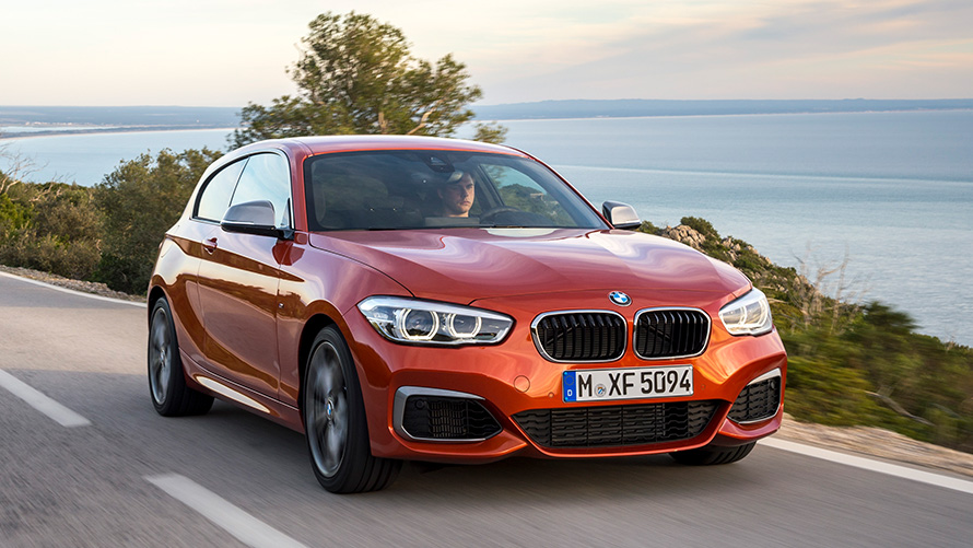 BMW M135i (F21) Three-quarter front view driving in front of lake and mountains BMW M135i (F21) Three-quarter front view driving in front of lake and mountains