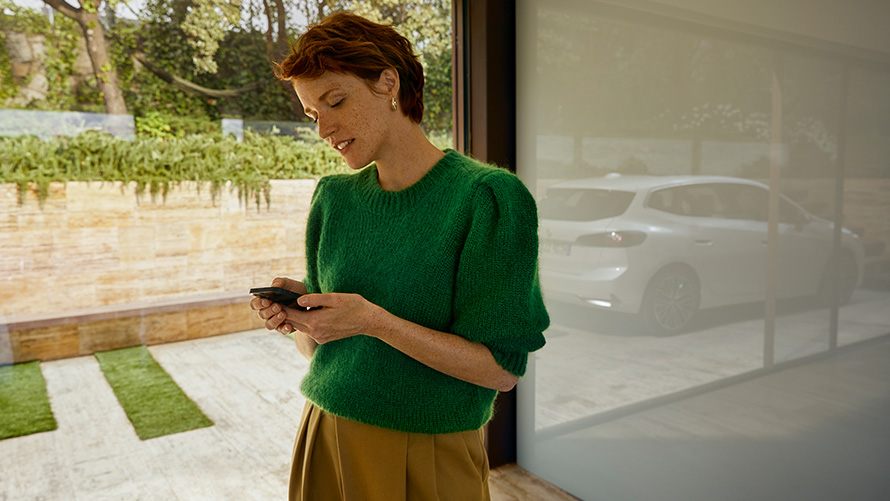 BMW Service Inclusive woman holding smartphone  Woman holding smartphone BMW Service Inclusive