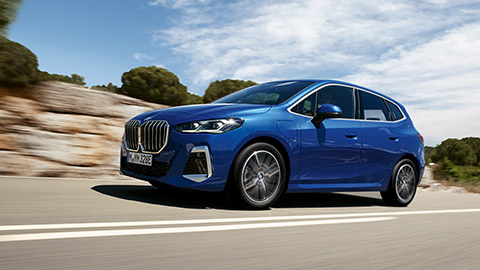 BMW 2 Series Active Tourer F45 three-quarter side view driving on the street BMW 2 Series BMW 2 Series Active Tourer F45 three-quarter side view driving on the street