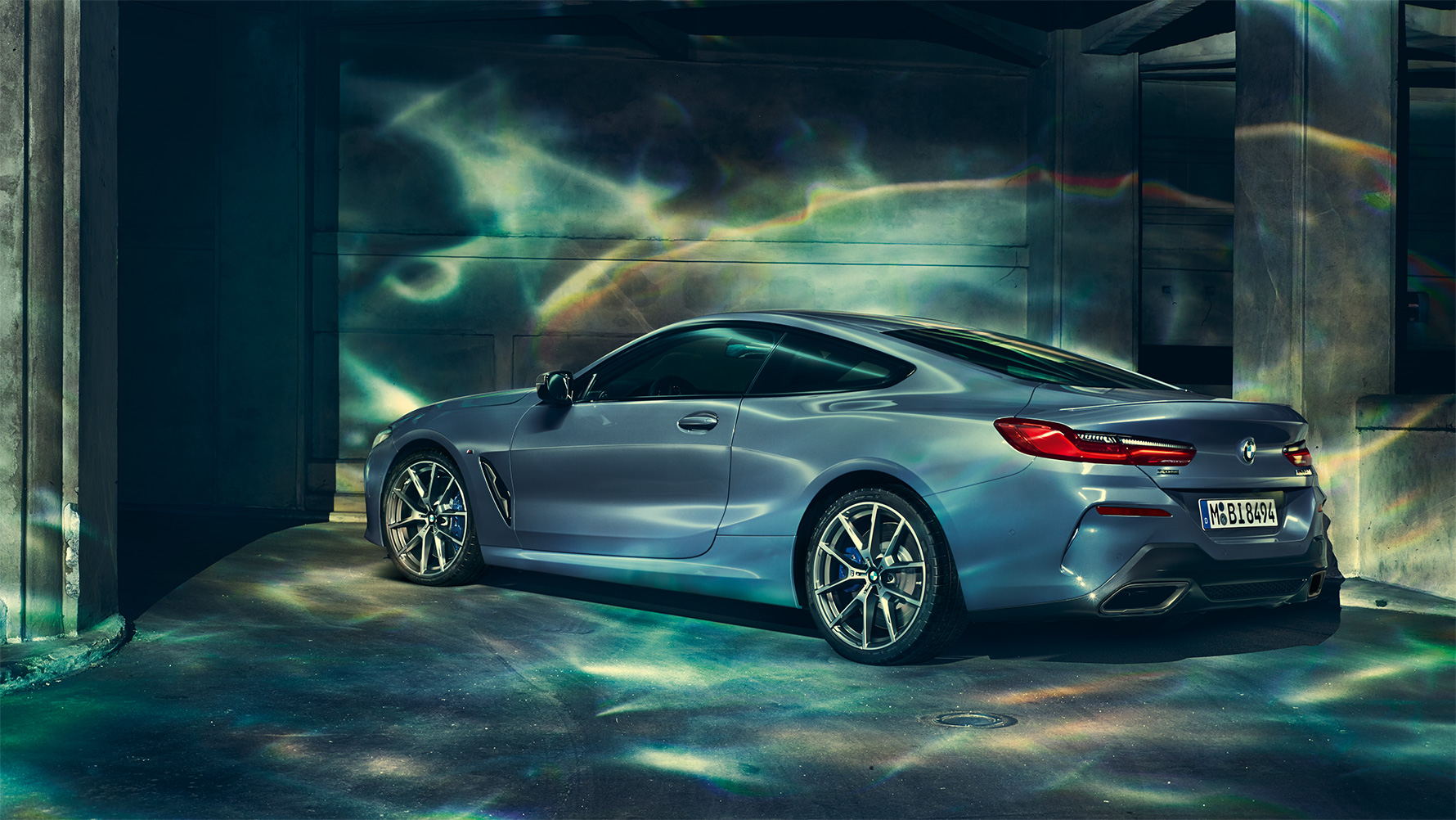 BMW 8 Series Coupé, three-quarter rear shot Three-quarter rear shot of the BMW 8 Series Coupé at night in front of an urban setting.