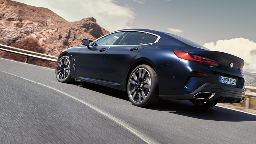 BMW 840i xDrive Gran Coupé G16 LCI Facelift 2022 BMW 840i xDrive Gran Coupé G16 LCI Facelift 2022 Portimao Blue metallic three-quarter front rear driving on a mountain road