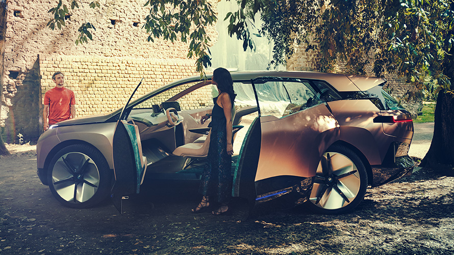 Side BMW Vision iNEXT Seite BMW Vision iNEXT mit Frau an geöffneter Tür und Mann im Hintergrund Side BMW Vision iNEXT with woman at open doors and man in the background