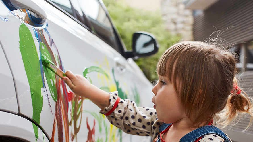 Repair and care Child paints a BMW with brush and paint