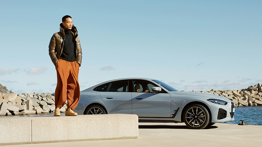 BMW Value Service BMW Service Inclusive BMW Service Inclusive man in front of BMW i4 on the coast