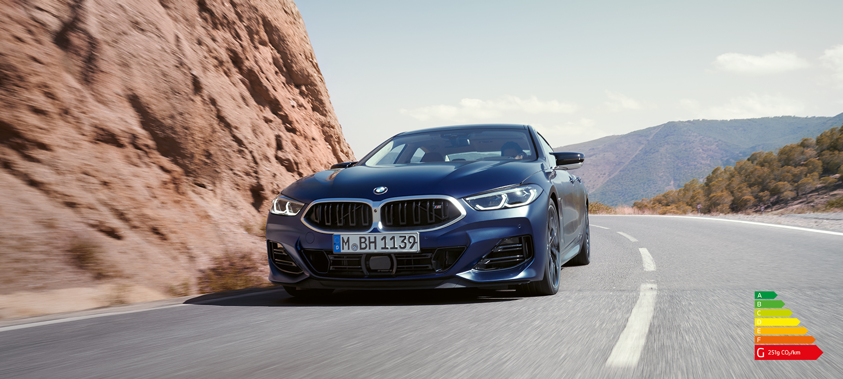 BMW 8 Series Gran Coupé G16 LCI Facelift 2022 BMW Individual Frozen Tanzanite Blue metallic three-quarter front view driving on a mountain road