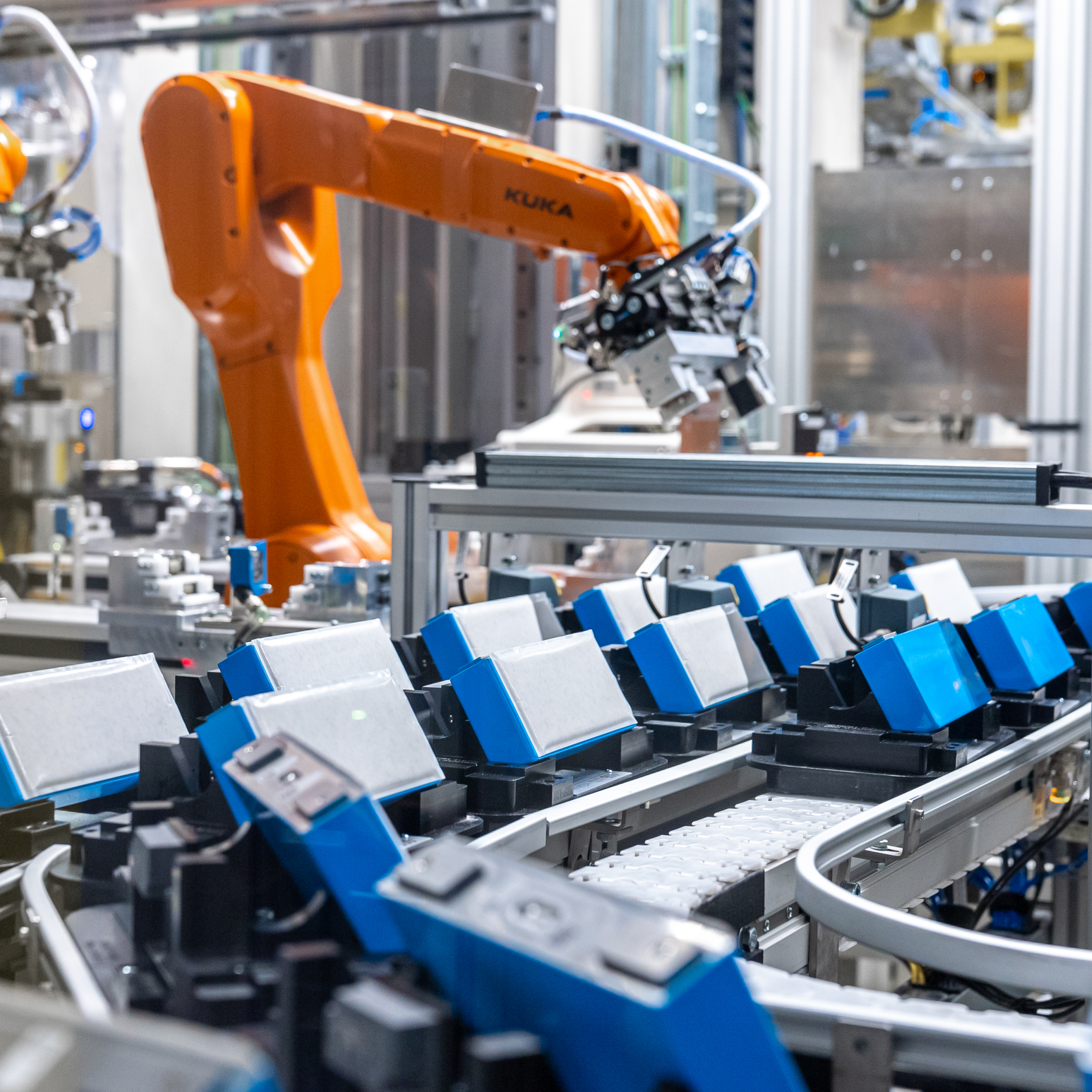Close-up of several blue and white batteries on a conveyor belt at a BMW plant